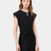 Vestido negro drapeado con detalle perforado característico.